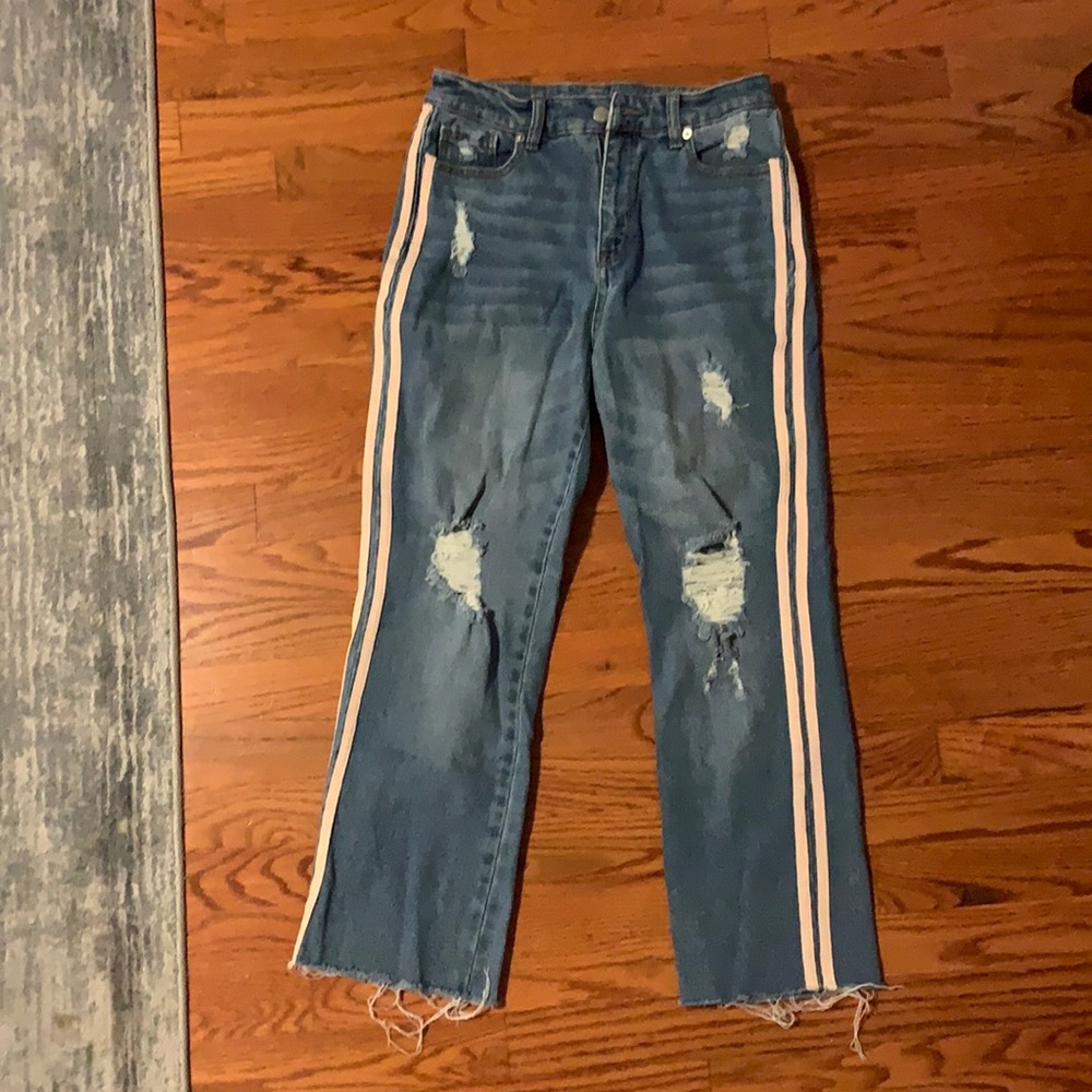 blue ripped jeans with two pink strips down both legs